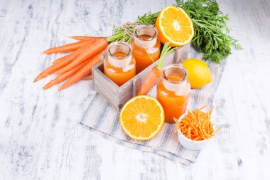 Havuçtan taze meyve suyu, portakal ve limon. Yapraklı havuç. 