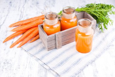Kavanozda taze havuç suyu. Yapraklı taze havuç ve içecek.