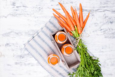 Kavanozda taze havuç suyu. Yapraklı taze havuç ve içecek.