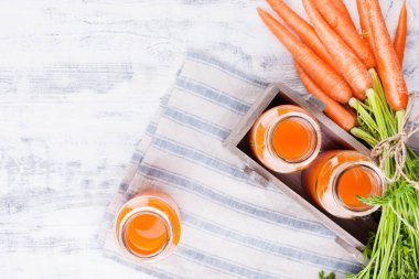 Kavanozda taze havuç suyu. Yapraklı taze havuç ve içecek.