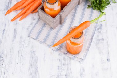 Kavanozda taze havuç suyu. Yapraklı taze havuç ve içecek.