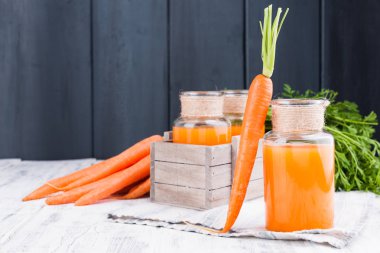 Kavanozda taze havuç suyu. Yapraklı taze havuç ve içecek.