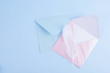 Mavi sırt çantasındaki harfler için beyaz tüyler ve renkli zarflar.