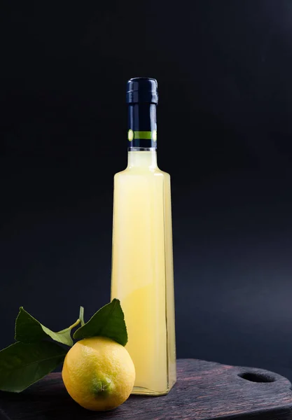 Lemoncello i en flaska på svart bakgrund, Traditional Italia — Stockfoto