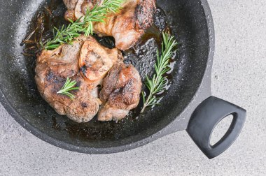 Öğle yemeği için tavada kızartılmış büyük et parçaları. Kalp ve sağlık