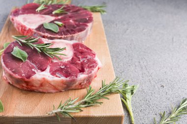 Ahşap bir tahtanın üzerinde kesilmiş et ve baharatlar. Çiğ et