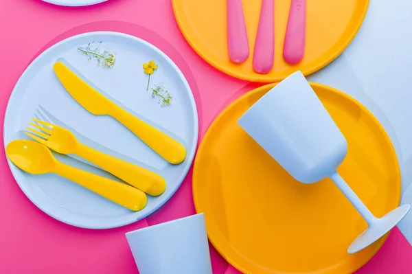 Blue plastic plates and cutlery and glasses. Dishes for a summer