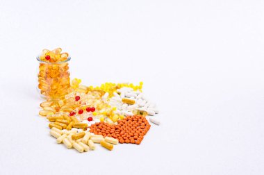Beyaz arka planda haplar ve vitaminler. Başlıktaki farklı uyuşturucular