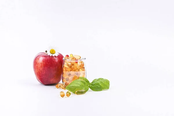 Jablka a vitamíny v kapslích na bílém pozadí. Volné místo — Stock fotografie