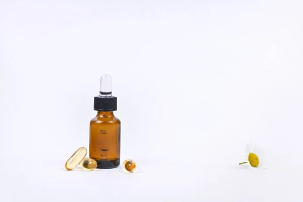 Капсула с пипеткой для витаминов и масла на белой спинке — стоковое фото