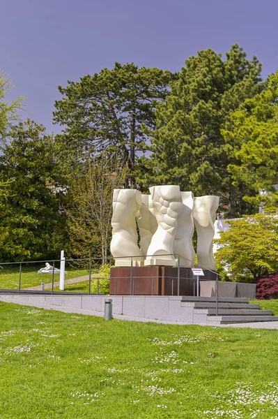 Grande sculpture blanche dans le parc du Musée Olympique. Fleurs — Photo