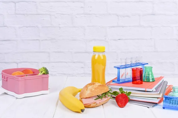 Déjeuner scolaire sur une table en bois blanc et un tableau noir pour les leçons . — Photo