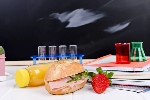 School lunch on the table and a blackboard for a lesson. Childre