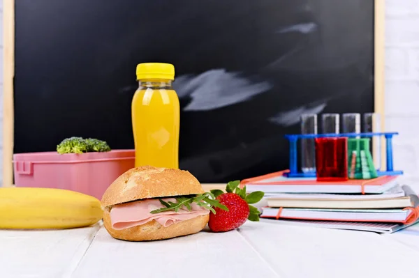 School lunch on the table and a blackboard for a lesson. Childre