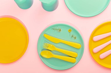 Parlak renkli plastik piknik aletleri. Pembe, sarı, mavi