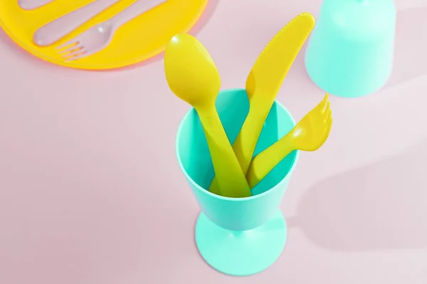 Bright colored plastic picnic utensils. Pink, yellow, blue color — Stock Photo, Image