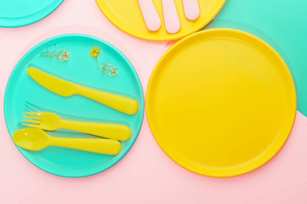 Bright colored plastic picnic utensils. Pink, yellow, blue color — Stock Photo, Image