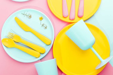 Parlak renkli plastik piknik aletleri. Pembe, sarı, mavi
