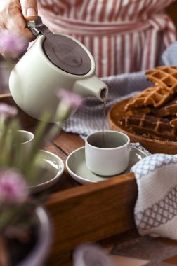 Bir kadın çay bardağının içine çay döker. Rahat atmosfer ve homemad