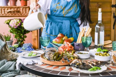 Mavi önlüklü mutlu bir kız dinn'de bir karafe su tutar.