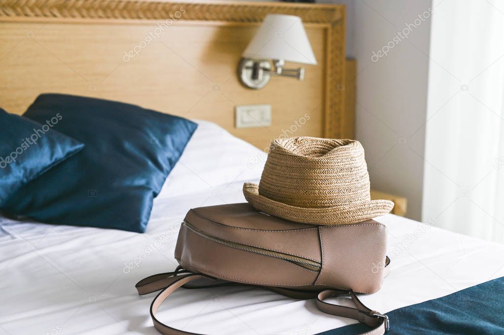 Straw hat and backpack in the hotel room. Travel and tourism. Th
