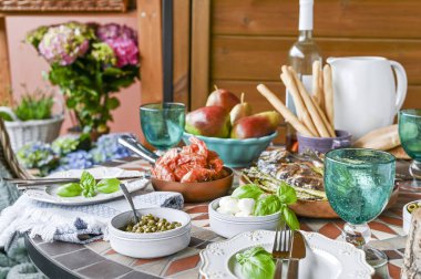 Farklı gıdalar, aperatifler ve çiçekler ile yemek masası. Yaz lu