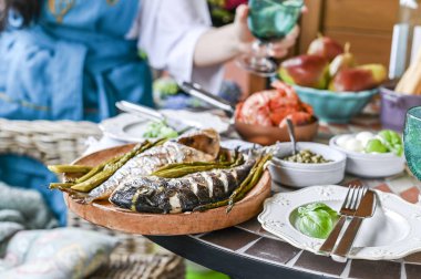 Elinde cam olan bir kadın. Farklı foo ile yemek masası