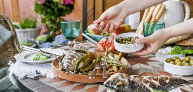 Elinde tabak olan bir kadın. Farklı foo ile yemek masası