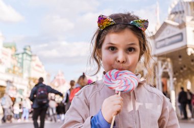 Büyük lolipop ile küçük kız oynuyor ve p eğleniyor
