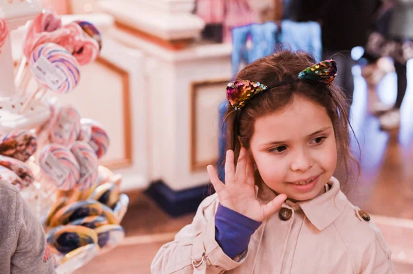 Kleines Mädchen mit großem Lutscher spielt und hat Spaß in der S — Stockfoto