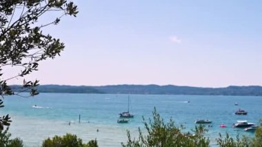 Göldeki yatlar ve birçok genç insan. Mavi Göl ve Alpler çevresinde. Yaz istirahati.