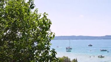 Göldeki yatlar ve birçok genç insan. Mavi Göl ve Alpler çevresinde. Yaz istirahati.