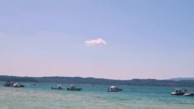 Göldeki yatlar ve birçok genç insan. Mavi Göl ve Alpler çevresinde. Yaz istirahati.