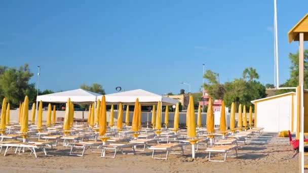 Strand Bij Zonsopgang Met Gele Parasols Ligstoelen Buurt Van Het — Stockvideo