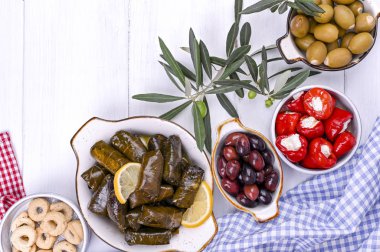 Geleneksel Yunan mutfağı. Üzüm yapraklarına sarılmış pirinç. Limonlu, baharatlı, çeşitli zeytinli ve acı biberli Dolma. Taze dallar ve ev yapımı yiyecekler..