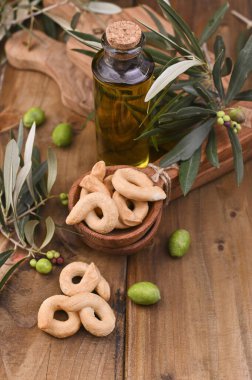 Taze ekmek ve taze zeytin dalıyla teneke kutularda yeşil zeytinler, eski ahşap zeminin üzerinde bir şişe zeytin yağı. Metin için boşluk 