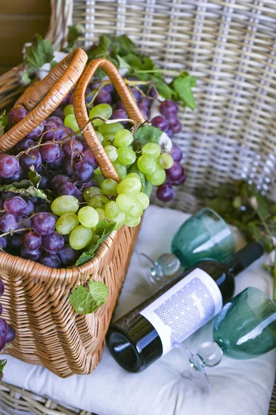 Trauben in einem Korb und eine Flasche Wein. in einem Landhaus. Sammlung ausgewählter Trauben für hausgemachten Wein. ökologische Produkte — Stockfoto