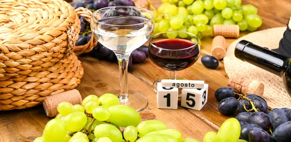 Traditionelles italienisches Erntefest, Symbol des Sommerurlaubs. Text vom 15. August auf Kalenderwürfeln. Auf einem hölzernen Hintergrund ergießt sich Wein aus einer Flasche in ein Glas. — Stockfoto