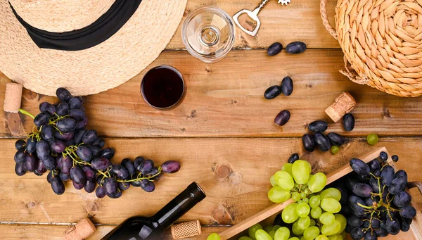Trauben, eine Flasche Wein, Glas mit Wein, Hut auf einem hölzernen Hintergrund. Blick von oben. Weinbereitungs- und Erntekonzept in Europa, Italien. Banner. Langformat. Kopierraum — Stockfoto