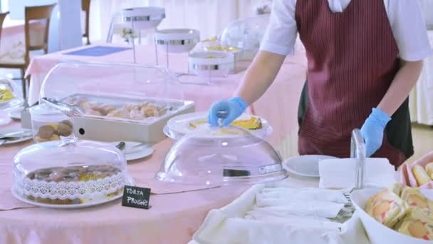 Frukost på hotellet, nya villkor för service av besökare och gäster. Personal, en kock i handskar och masker distribuerar mat till lunch. Begreppet turism sommaren 2020 på orten. — Stockvideo