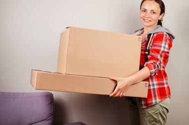 Paketi açıyorum. Kadın kutuyu açıyor ve internetten satın aldıklarını mutlulukla alıyor. Teslimat ve servis konsepti. İnternetten alışveriş. Bu kişi Avrupalı. Metin için boş alan.