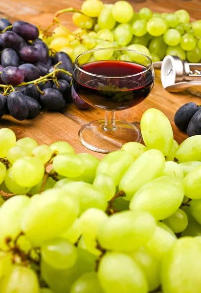 Traditioneller italienischer Feiertag und Sommerurlaub, Erntedankfest Ferragosto. Rot- und Weißwein auf hölzernem Hintergrund und Trauben. — Stockfoto