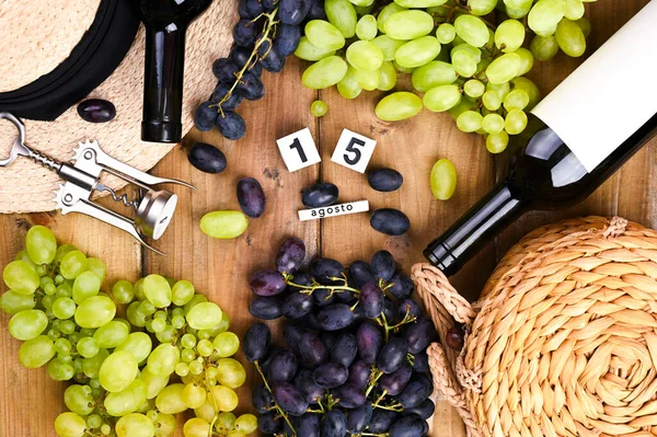 Traditioneller italienischer Feiertag und Sommerferien, 15. August auf einem Würfelkalender. Erntedankfest Ferragosto. Rot- und Weißwein auf hölzernem Hintergrund und Trauben — Stockfoto