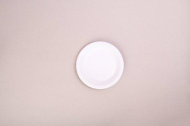 Gri arka planda kağıt beyaz bir plaka. Eko cam geri dönüşüm konsepti. Üst Manzara. Metin için boş alan. Model