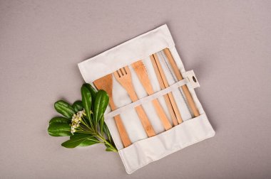 Bambu ağacından yapılmış çevre dostu tek kullanımlık aletler. Örtülü kaşıklar, çatallar, bıçaklar, bambu kaseleri ve tekstil örtüsü. Geri dönüşüm ve doğal malzemeler kavramı.. 