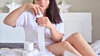 Kinesio kasetleri bir kadın tarafından tutuluyor. Bir insan aydınlatma odasında kinesio bandı kullanır. Sağlık konsepti ve güzel bir vücut..