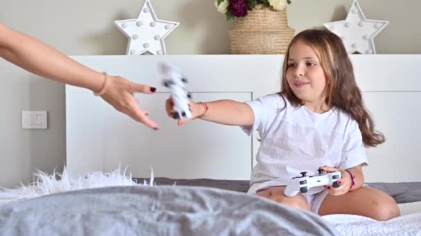 Menina e mãe estão jogando um jogo de computador com a mãe. Jostics na mão. Jogos de computador modernos para crianças e pais. Divulgação de emoções alegres por pessoas. Imagens 4k de alta qualidade — Vídeo de Stock