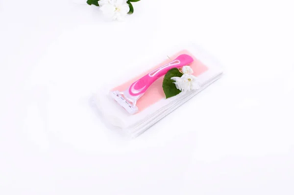 A set of different means for epilation on a colored background. Removal of unwanted hair. Body care products, towels, jasmine flowers, wax strips, razor. Minimalism, top view. flatlay. — Stock Photo, Image