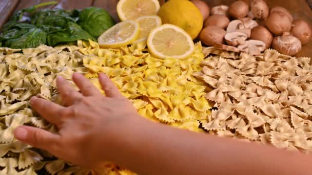 Varie paste secche italiane. Con spinaci, funghi e sapore di limone. La mano prende la pasta. — Video Stock