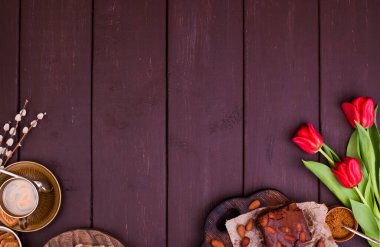 Tahta bir masada taze aromatik espresso ve browni. Bahar kahvaltısı, çiçekler, laleler, hamur işleri ve kahve. Üst Manzara. Metin için boş alan.